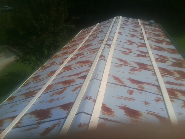 Rusted metal roof panels with new wood purlins before replacement — Storm Damage Roof Repair in Waupun by Roofing Brothers
