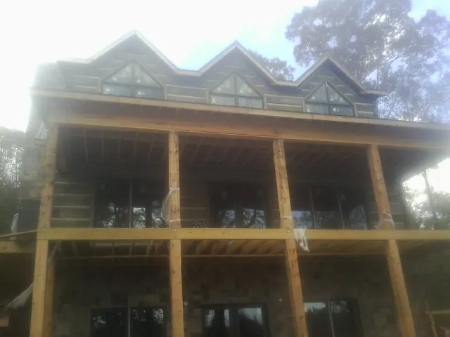 Dormers and porch framing on a large log home under construction — Roof Coating work by our crew in Waupun